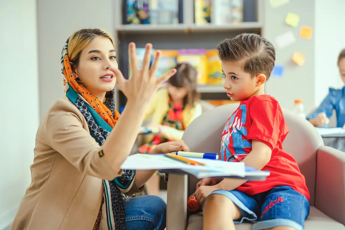 Profesional guiando una actividad manual con un niño